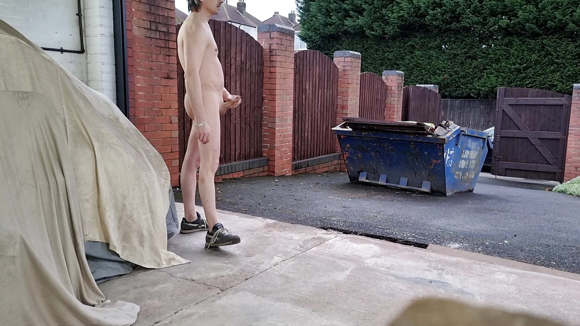 Walking around the garage with the door open, naked.