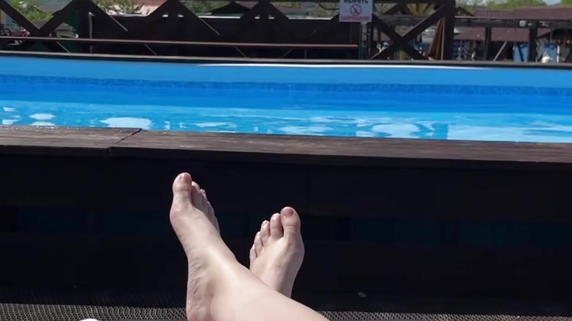 Feet relaxing by the pool