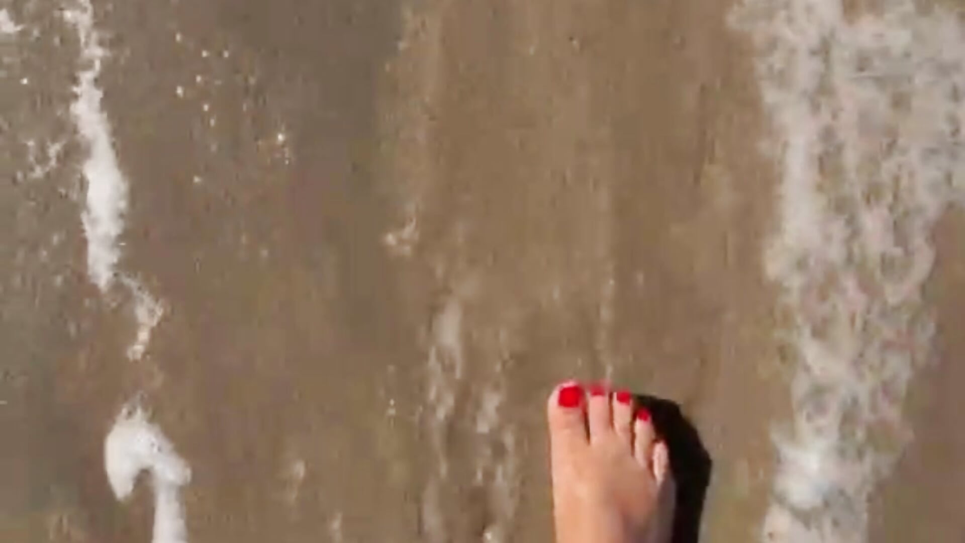 Red toes on beach