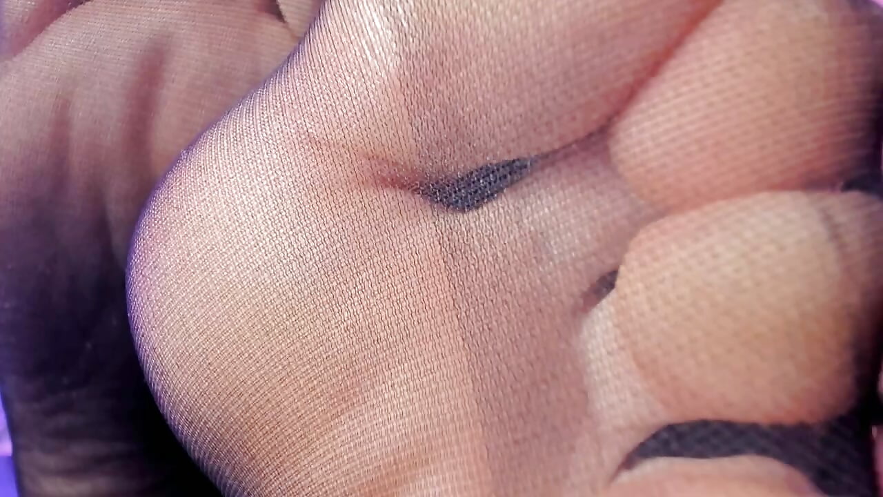 Toes in black nylon close up